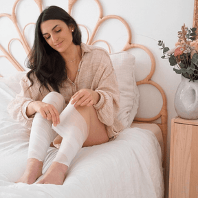 Mannequin femme appliquant les bandages remodelants et drainants sur un lit